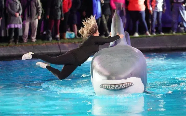 Erica Dechowitz salta de uma prancha para um tubarão na segunda temporada de Holey Moley, o tipo de desafio que podemos ver em Frogger, que está chegando ao Peacock