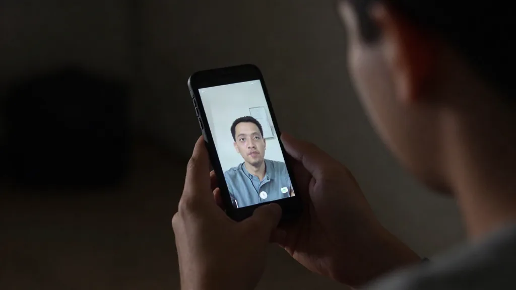 Alguien viendo un vídeo vertical en el móvil a oscuras